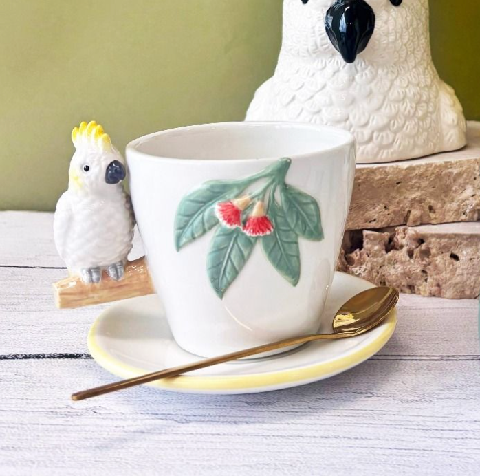 
                  
                    Urban Products Cocky Tea Cup & Saucer styled with matching cockatoo-themed kitchenware
                  
                